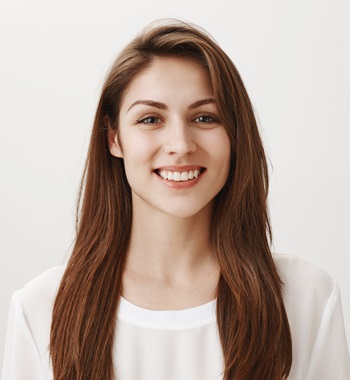 Girl is happy receive good feedback about her site. Portrait of attractive caucasian woman in white shirt smiling broadly, looking with satisfied expression at camera, feeling great after day in spa. Emotions concept